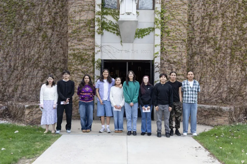 Die Absolventen der St. Josefs High School standen vor der Kapelle „Unserer Lieben Frau von den Sioux“ und begrüßten die Gemeindemitglieder vor dem Abschlussgottesdienst.