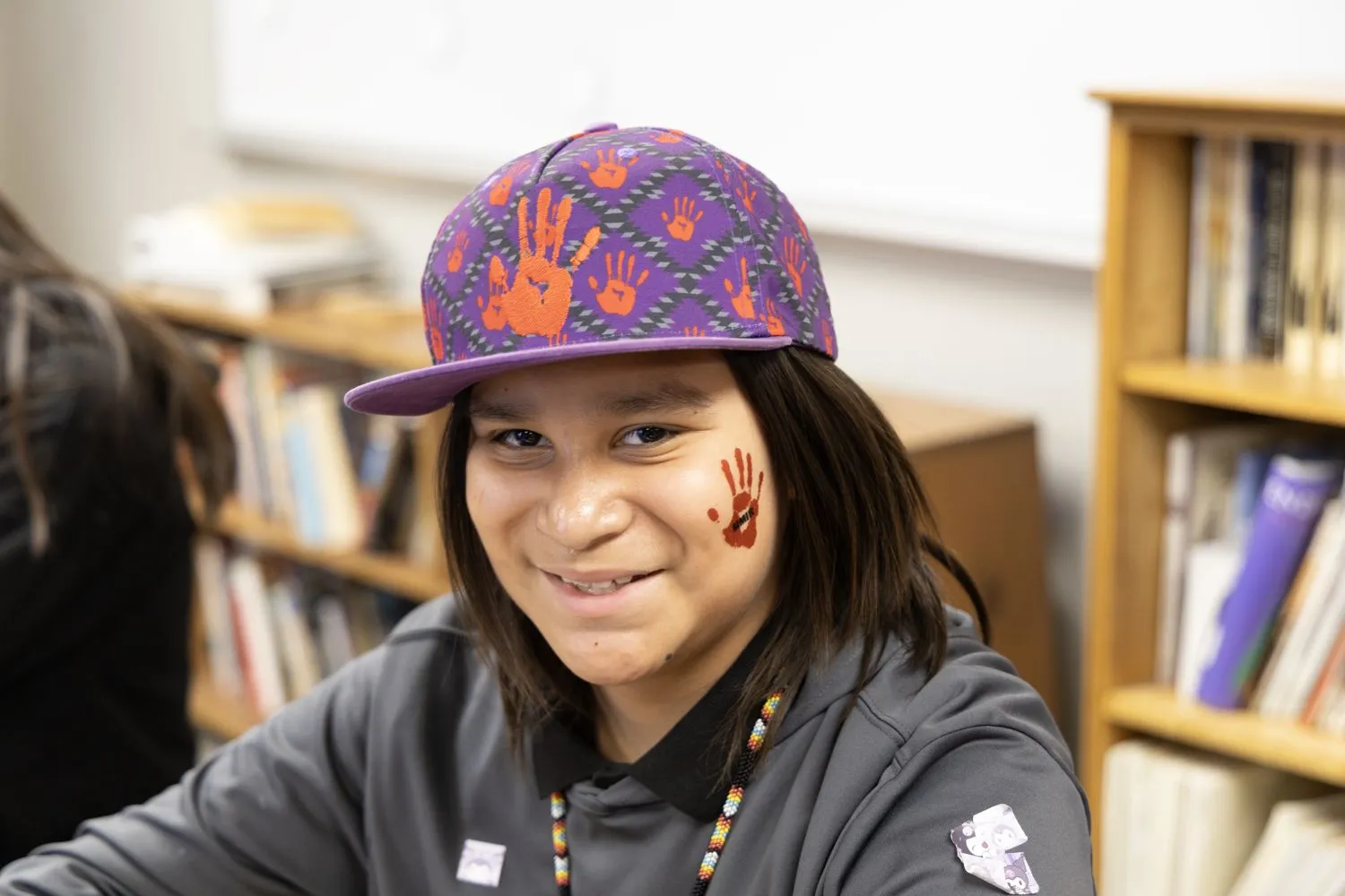 Ein Schüler der St. Josefs Indianerschule lächelt, während er sein temporäres rotes Handabdruck-Tattoo zu Ehren des Tages der vermissten und ermordeten indigenen Verwandten (MMIR Day) trägt.