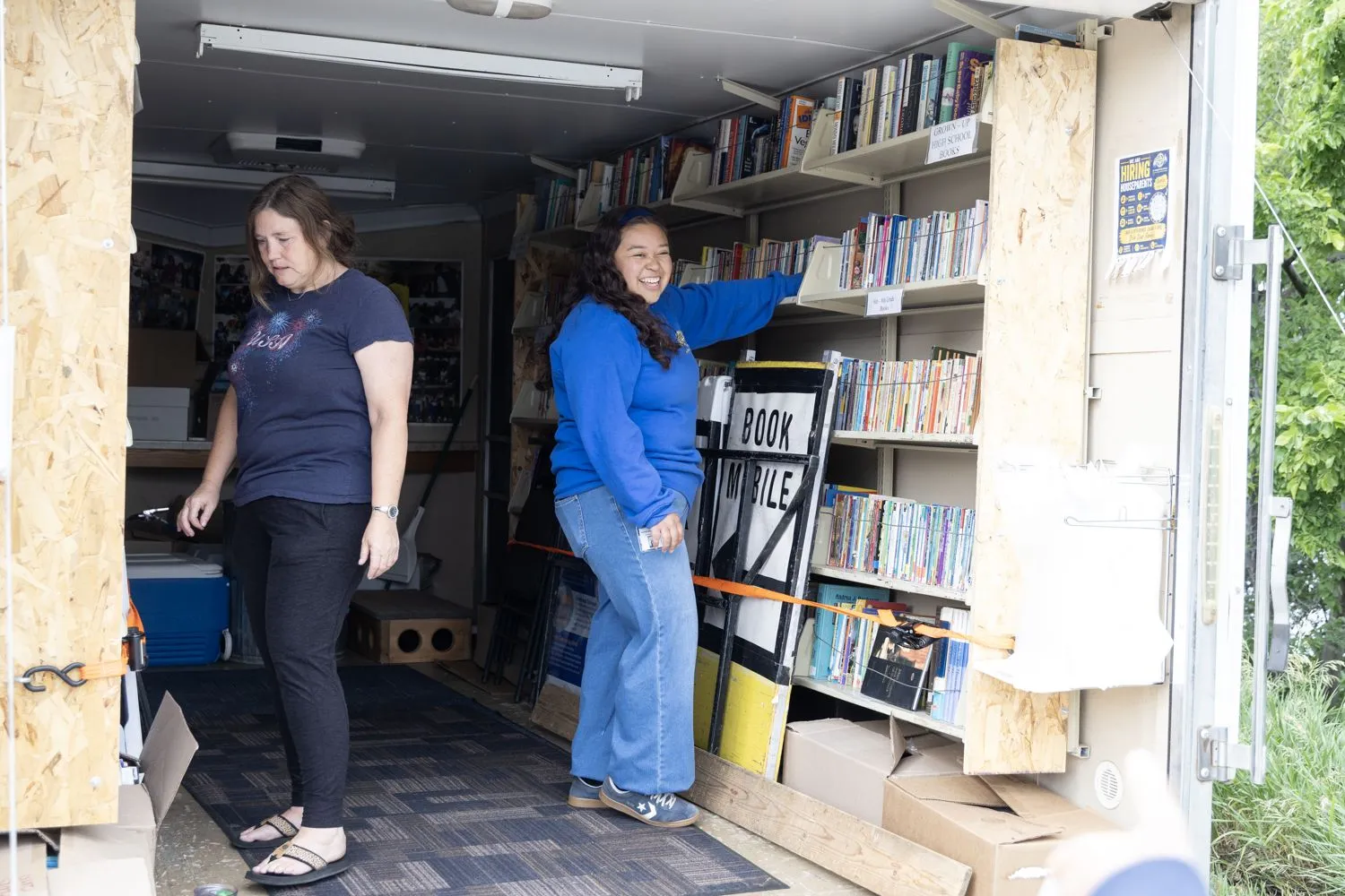 Die Praktikantin Alexandra (rechts) füllt die Regale des Bücherbusses wieder mit Büchern auf, bevor dieser durch Süddakota fährt.