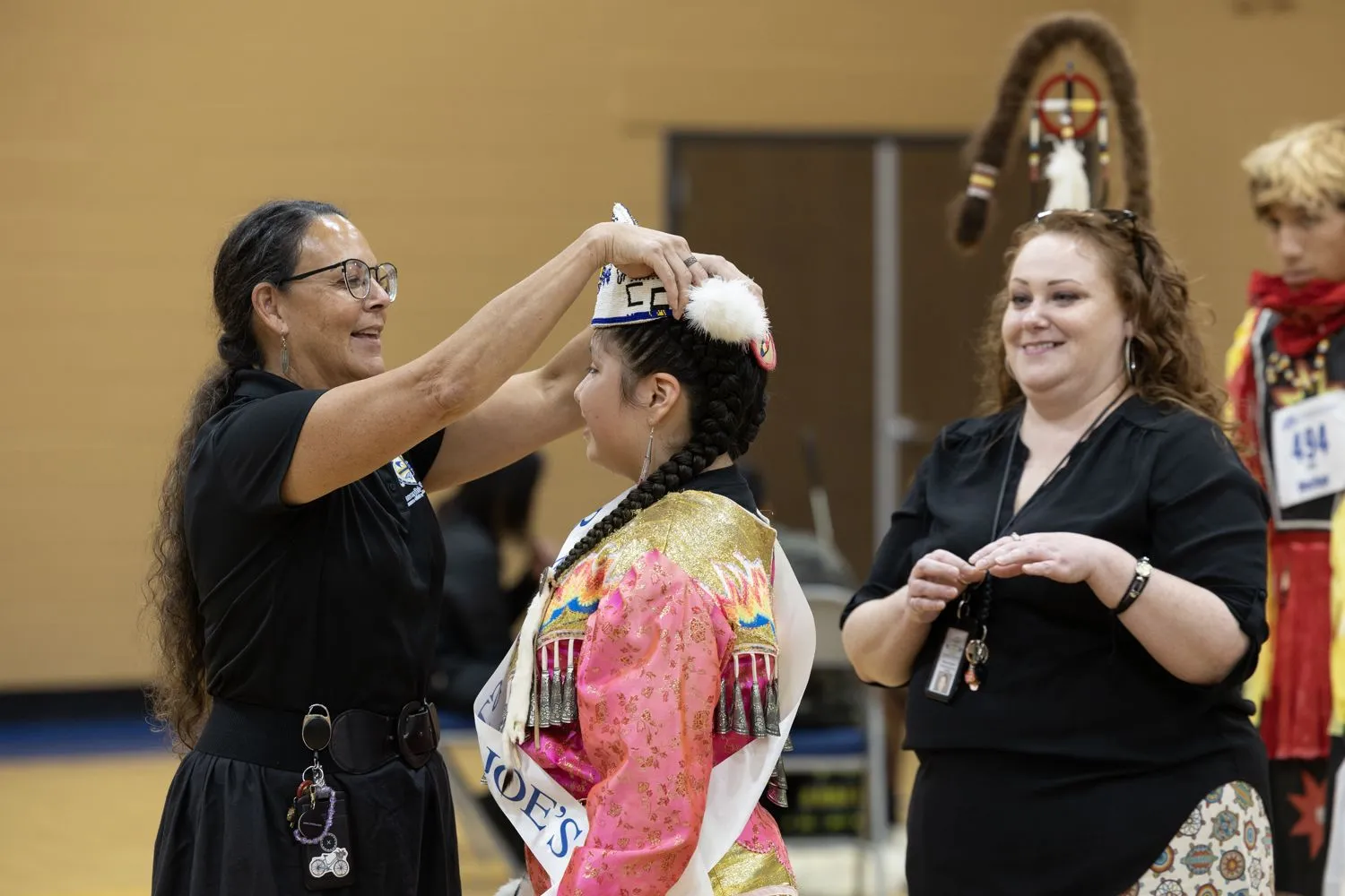 Arihanni, die diesjährige Junior Miss St. Josefs, wird von LaRayne, der Leiterin des Fachbereichs Native American Studies an der St. Josefs, gekrönt.