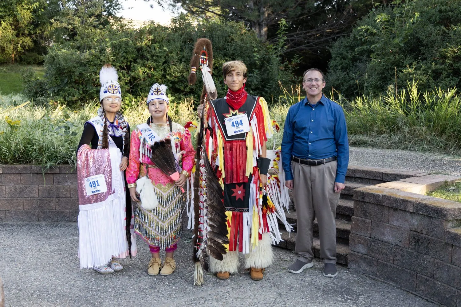 Die 2026 Powwow-Royals von St. Josefs versammeln sich nach dem Wettbewerb mit Pater Greg Schill, SCJ. Gemeinsam verkörpern sie Führungsqualitäten, kulturellen Stolz und den Geist des Dienens an der St. Josefs Indianerschule.