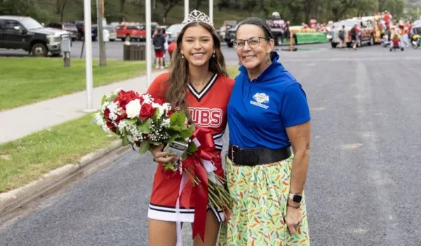 Queen Makaia und die Native American Studies-Lehrerin LaRayne lächeln während der „Homecoming-Parade“ von Chamberlain für ein Foto.
